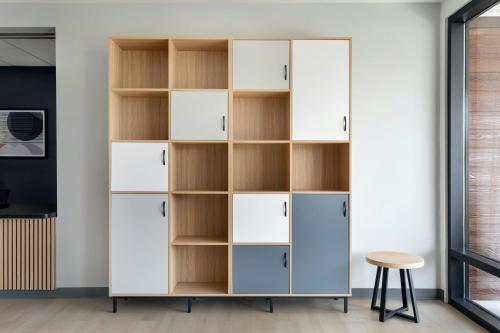 a large white wardrobe with shelves and a stool at StudioRes by Marriott Jackson, TN in Jackson