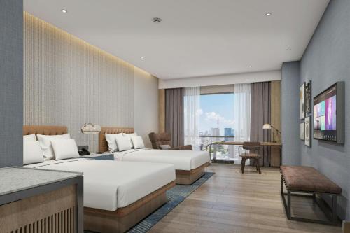 a hotel room with two beds and a television at Four Points by Sheraton Jinan, High-Tech Zone in Jinan