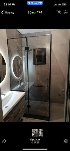 a bathroom with a glass shower and a sink at Zhailoo Guest House Kochkor in Kochkorka