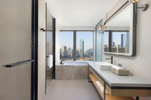 a bathroom with a tub and a sink and a window at Four Points by Sheraton Jinan, High-Tech Zone in Jinan