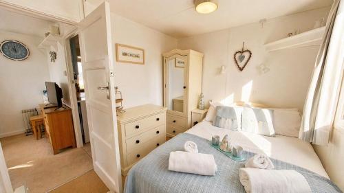 a bedroom with a bed with towels on it at F71 Elova, Riviere Towans in Hayle