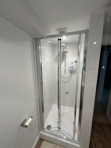 a shower with a glass door in a bathroom at Hornbeams Annexe - Deluxe Apartment in Biddenden