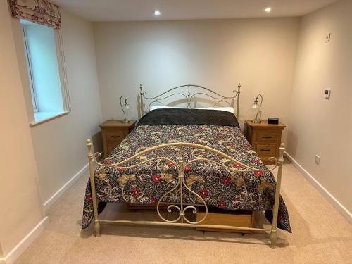 a bedroom with a bed with a quilt on it at Hornbeams Annexe - Deluxe Apartment in Biddenden