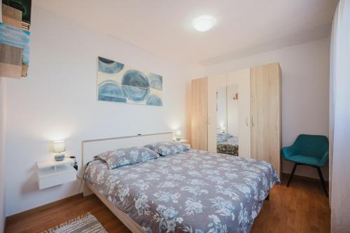 a bedroom with a bed and a green chair at Apartman Mimi - Pula airport in Pula