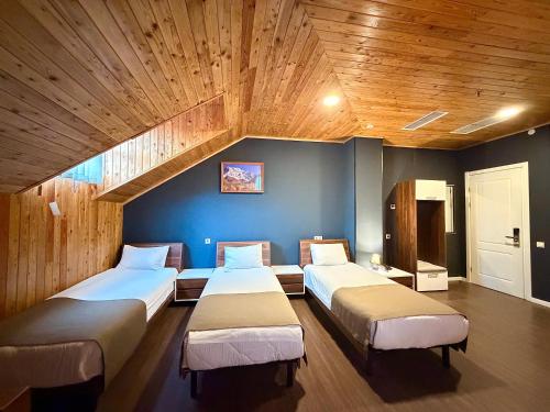 a bedroom with two beds and a wooden ceiling at Bricks Hotel in Tbilisi City