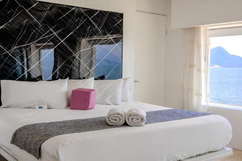 a bedroom with a large bed with two towels on it at Best Western Plus Luna del Mar in Manzanillo