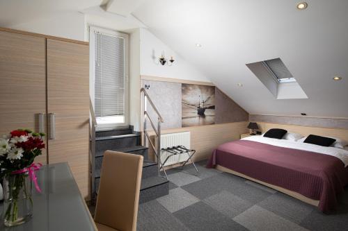 a bedroom with a bed and a staircase in it at Hotel Galija in Pula