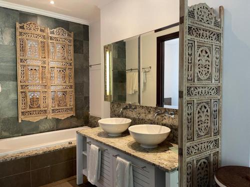 a bathroom with two sinks on a counter with a mirror at Maison Cinnamon by Simply-Seychelles in Eden Island