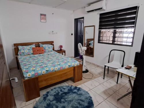a bedroom with a bed and a desk and a chair at 2 CHAMBRES SALON MEUBLé in Yamoussoukro