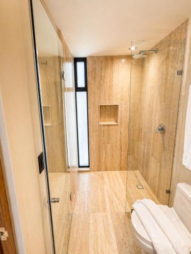 a bathroom with a shower and a toilet at Tuk Hacienda Studio Rooftop Pool Padel TUK in Tulum