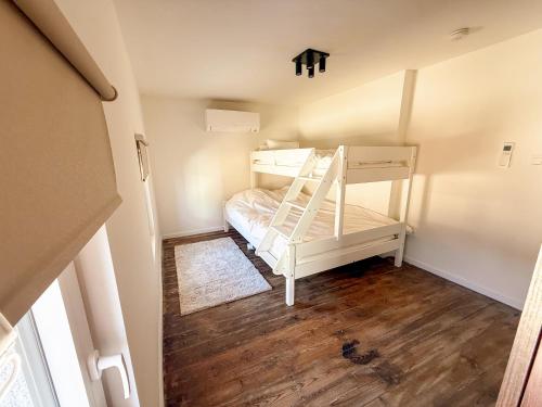 a small bedroom with a bunk bed and wooden floors at Vakantiewoning Goed Thuis in Dilsen-Stokkem
