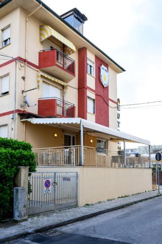a red and white building with a balcony at Hotel Laurin in Lido di Camaiore