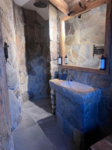 a stone bathroom with a sink and a mirror at Berry in Klatovy