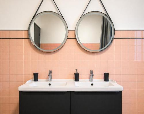 a bathroom with two mirrors above a sink at Maison 10 personnes 4 chambre 2 sdb in Liourdres