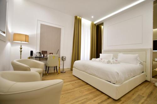 a bedroom with a white bed and a desk and chair at Domus De Cinti Charme Rooms in Tivoli