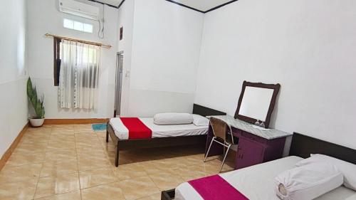 a room with two beds and a mirror in it at Labore Homestay in Waha