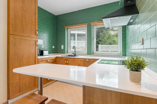 a kitchen with green walls and a white counter top at StoneBridge Riverside Mountain Apartments in Loriga