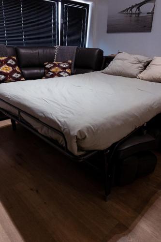 a large bed in a living room with a couch at Laurina's Cove in Ostend