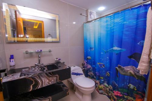 a bathroom with an aquarium shower curtain and a toilet at Premier Inn Gulberg Lahore in Lahore