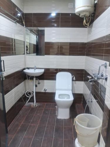 a bathroom with a toilet and a sink at The Royal Lavender in Rānchī