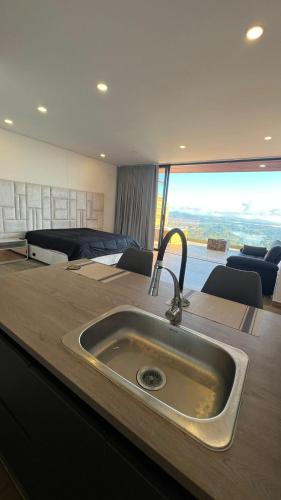 a kitchen with a sink and a large window at Montecielo Hosting in Guatapé