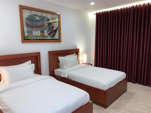a hotel room with two beds and a window at Hotel Viajante in Landusane
