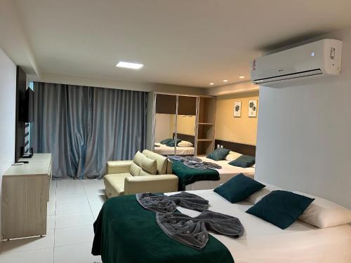 a hotel room with two beds and a living room at Flat Premium Sea View - Tabatinga Beach in Conde