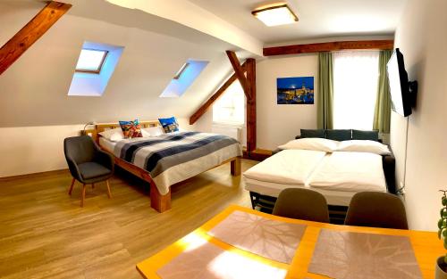 a bedroom with two beds and a table and chairs at Hotel Garni Villa Areka in Český Krumlov