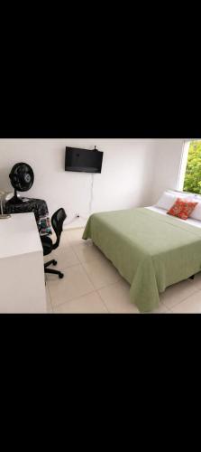 a bedroom with a green bed and a chair at Âncora Horto da barra in Barra dos Coqueiros