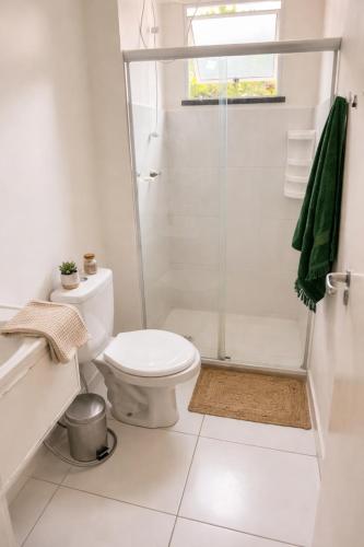 a white bathroom with a toilet and a shower at Âncora Horto da barra in Barra dos Coqueiros