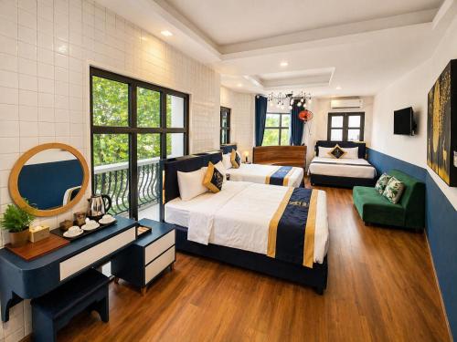 a bedroom with two beds and a balcony at Arina Luxury Hotel - Vincom Tay Ninh in Tây Ninh