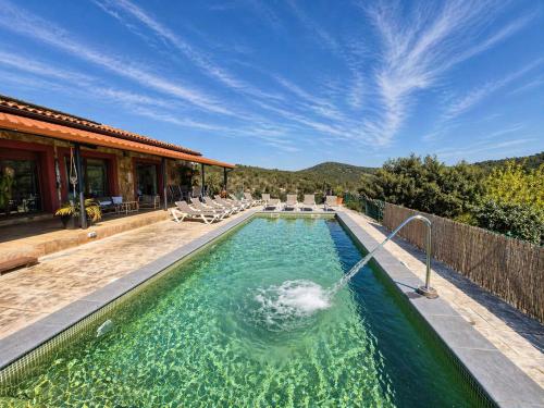 a swimming pool with a fountain in front of a house at Bravaholidays-625-Silence in Terra Brava