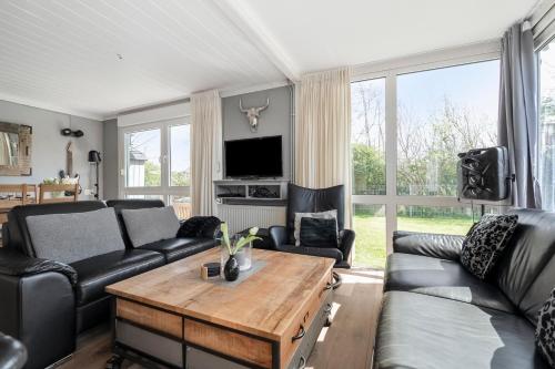 a living room with a couch and a table at Vakantiehuis Rumah Kami - Julianadorp aan Zee in Julianadorp