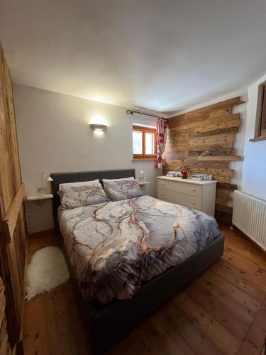 a bedroom with a bed and a wooden wall at Casa Lazer in Tonadico