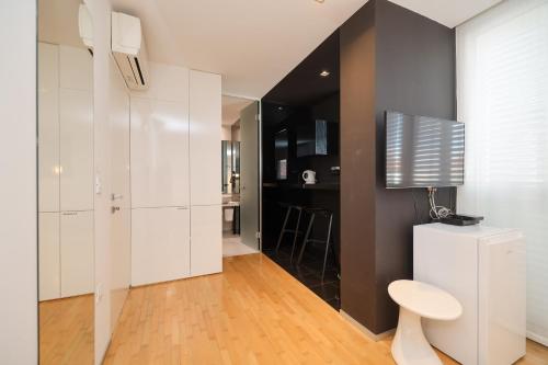 ein Wohnzimmer mit weißen Schränken und einem Fernseher an der Wand in der Unterkunft Unique Integrated Hotel in Zadar