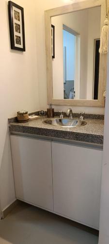 a bathroom with a sink and a mirror at Oasis Urbano Departamento Temporal in Santiago del Estero