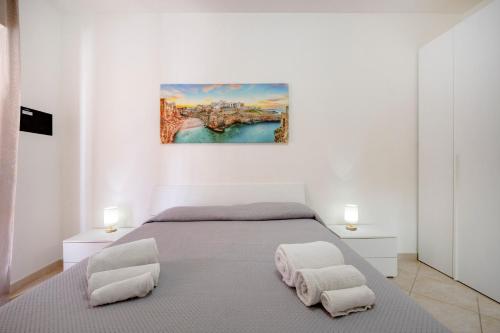 a white bedroom with a bed and two chairs at Levante Eight Sea View Apartment in Bari