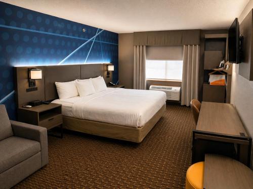 a hotel room with a bed and a chair at Comfort Suites Wisconsin Dells Area in Portage