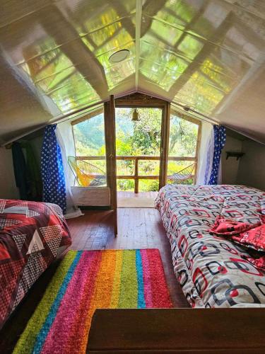 a bedroom with a bed and a rainbow rug at Aguadulce Climbing House in Choachí