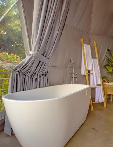 a white bath tub in a room with a tent at Cardedeu Domos in Álvarez