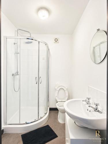 a bathroom with a shower and a sink and a toilet at Residency rooms Liverpool in Wallasey