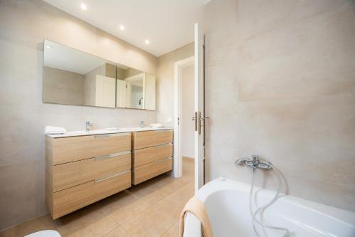 a bathroom with a tub and a sink at Villa Sa Caleta de Cala D'or in Santanyi