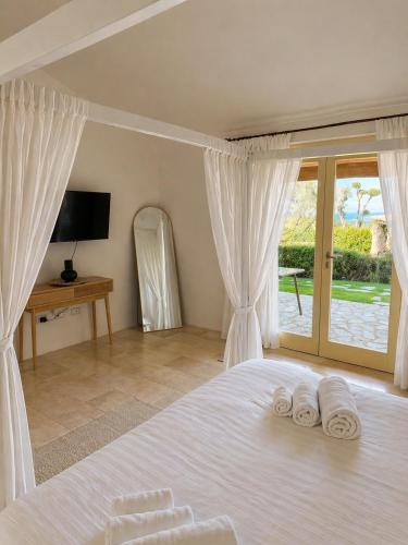 a bedroom with a bed with white sheets and a window at Pedra Smeralda in Golfo Aranci