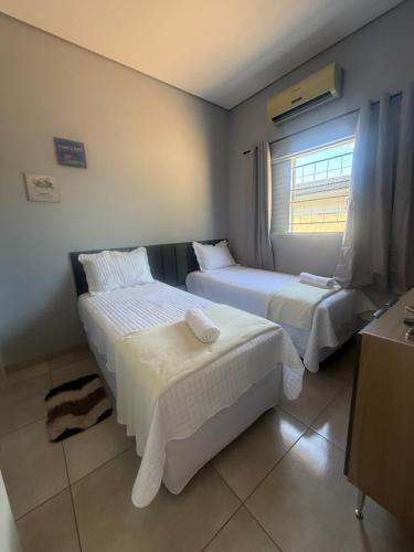 a hotel room with two beds and a window at Amazon Loft 09 in Sorriso