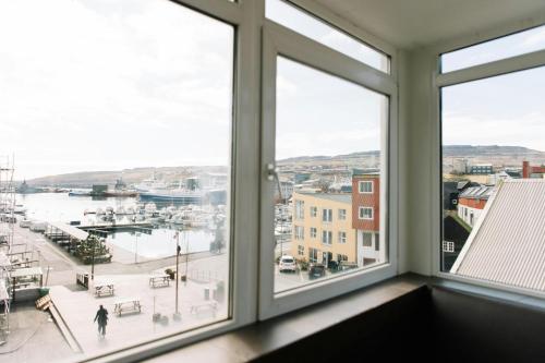 a room with windows looking out at a marina at Hotel Tórshavn in Tórshavn