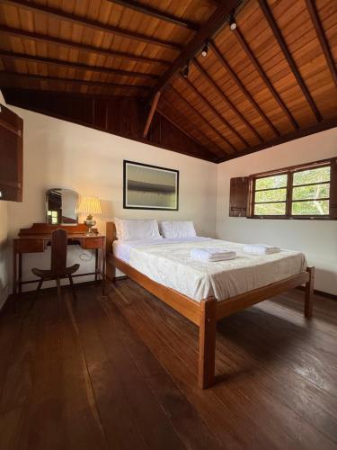 a bedroom with a bed and a desk and a bed sidx sidx sidx at Casa Sol Piscina e Cachoeira in Pirenópolis