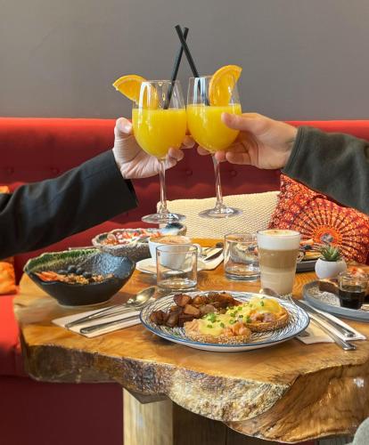 a table with two people holding glasses of orange juice at Bel Air Tremblant Hotel - Dômes & Chalets in Mont-Tremblant