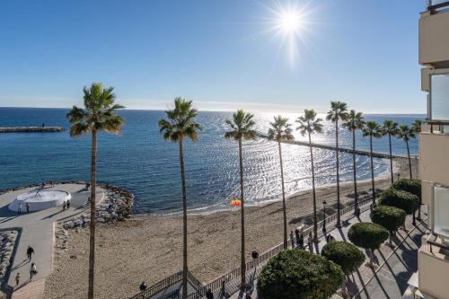 a view of a beach with palm trees and the ocean at Marbella Beachfront Studio with Stunning Sea Views in Marbella