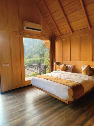 a bedroom with a large bed with a large window at The Corbett Lads in Tota Ām