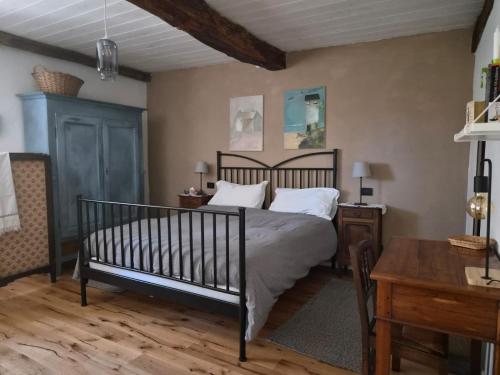 a bedroom with a bed with white pillows and a table at Casa Mondonio in Castelnuovo Don Bosco
